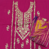 Pink fabric with white floral embroidery and a folded colorful fabric on top