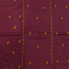 Maroon fabric with small embroidered floral patterns